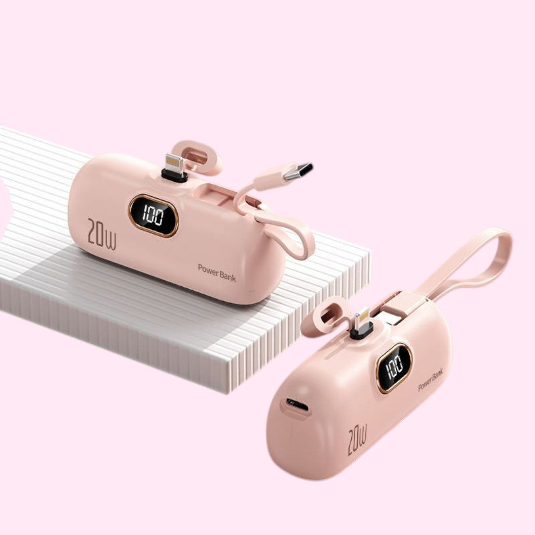 Power Bank rosa Chic Travel com visor digital, cabos Lightning e USB-C integrados e alça de transporte.